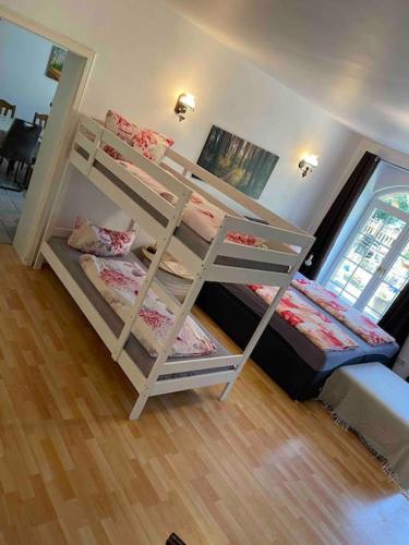 two bunk beds in a room with a wooden floor at Seeblick zwei im Waldschlößchen in Wendisch Rietz