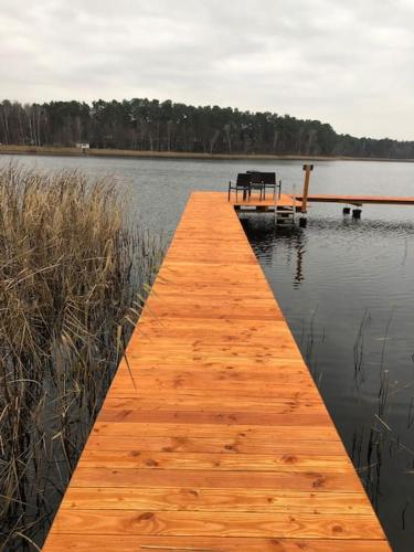 a wooden dock in the middle of a lake at Seeblick zwei im Waldschlößchen in Wendisch Rietz
