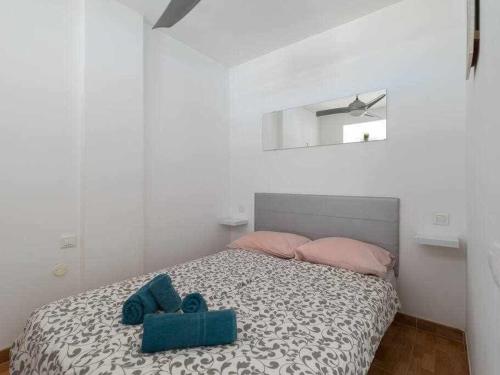 een slaapkamer met een bed met een blauw knuffeldier erop bij Marlenghi Apartments 412 in San Bartolomé