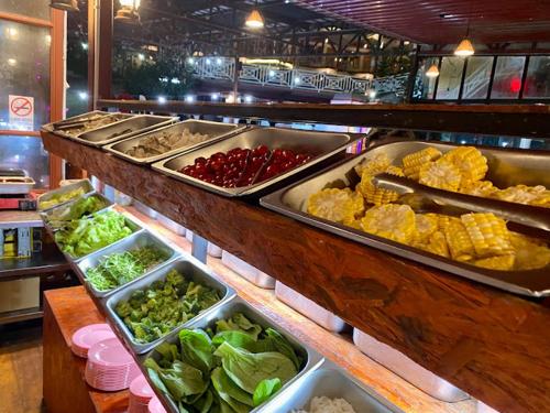 a buffet line with different types of vegetables in trays at BC Homestay @ Emerald Avenue Apartment, Brinchang in Brinchang