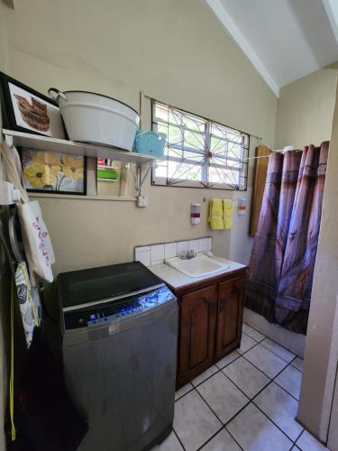 a small kitchen with a sink and a stove at La Kaye Nou by SMO Wellness in Soufrière
