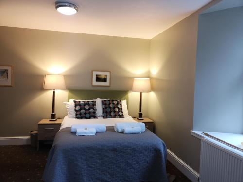 a bedroom with a bed with two towels on it at Raasay House Hotel in Raasay