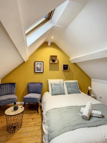 une chambre mansardée avec un lit et une chaise dans l'établissement Magnifique studio centre ville Saint Leu 2 pers, à Amiens