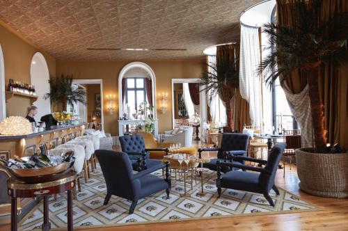 a lobby with chairs and tables and a bar at Chateau de Sacy in Sacy