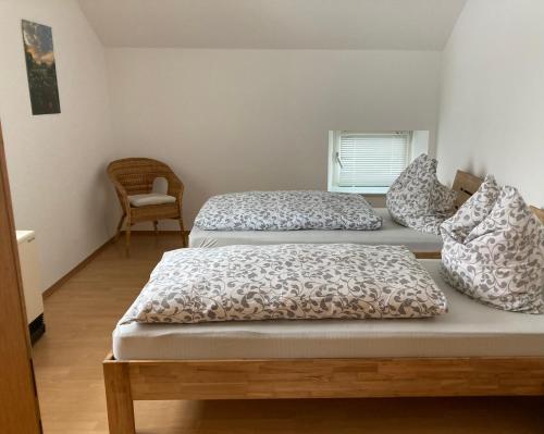 three beds in a room with a chair at Ferienwohnung Zweinig02 in Roßwein