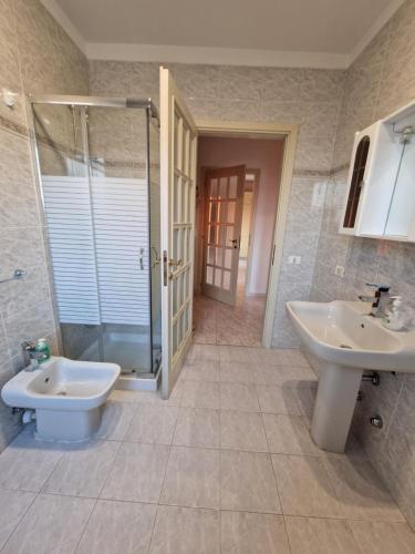 ein Badezimmer mit zwei Waschbecken, einer Dusche und einem WC in der Unterkunft Appartamento Divino Tramonto in Altedo