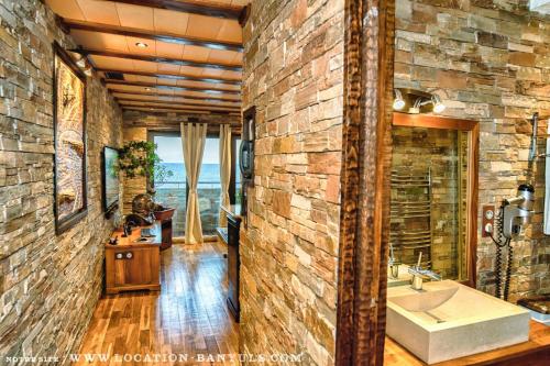 a bathroom with a stone wall and a sink at Location de charme de Thierry BOURGAIT in Banyuls-sur-Mer