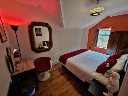 um quarto com uma cama, uma secretária e um espelho em Southsea Royale James Bond 3 bed Cool Penthouse, seafront parking em Portsmouth