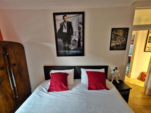a bedroom with a bed with two red pillows at Southsea Royale James Bond 3 bed Cool Penthouse, seafront parking in Portsmouth