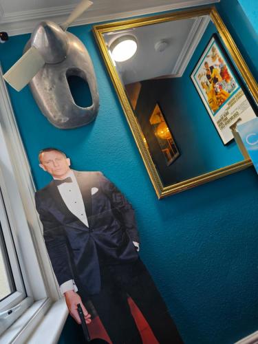 a picture of a man in a suit and a mask on a wall at Southsea Royale James Bond 3 bed Cool Penthouse, seafront parking in Portsmouth