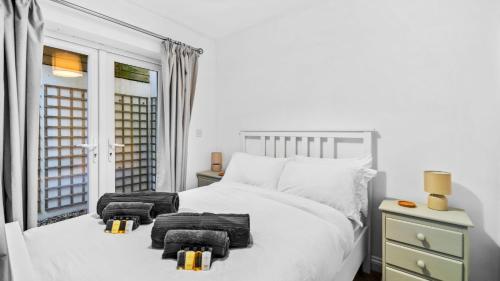 a white bedroom with a large white bed and a window at Cotswold Road North in Bristol