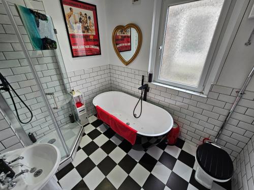 a bathroom with a bath tub and a sink at Southsea Royale James Bond 3 bed Cool Penthouse, seafront parking in Portsmouth