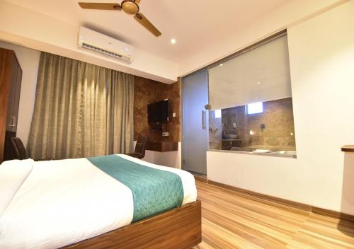 a bedroom with a bed and a large window at Hotel Candor Amigo Airoli Mind Space in Navi Mumbai