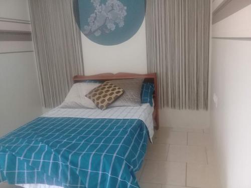 1 dormitorio con 1 cama con edredón azul en Douglas Airport Guesthouse en Zanderij
