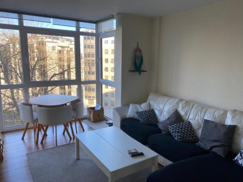 ein Wohnzimmer mit einem Sofa und einem Tisch in der Unterkunft Green apartment in A Coruña