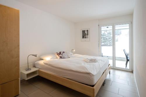 um quarto branco com uma cama grande e uma janela em CASA BELLINA em Davos