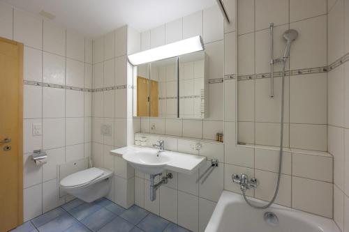uma casa de banho com um lavatório, um WC e um chuveiro em CASA BELLINA em Davos