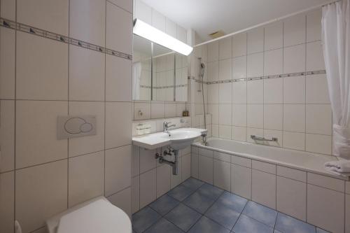 a bathroom with a sink and a tub and a toilet at CASA BELLINA in Davos