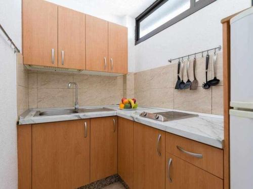 a kitchen with wooden cabinets and a sink at Marlenghi Apartments 818 in San Bartolomé de Tirajana