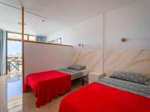 a room with two beds and a red blanket at Marlenghi Apartments 818 in San Bartolomé de Tirajana