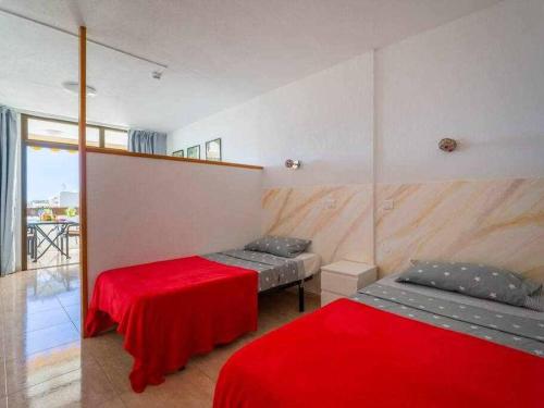 een kamer met 2 bedden en een rode deken bij Marlenghi Apartments 818 in San Bartolomé