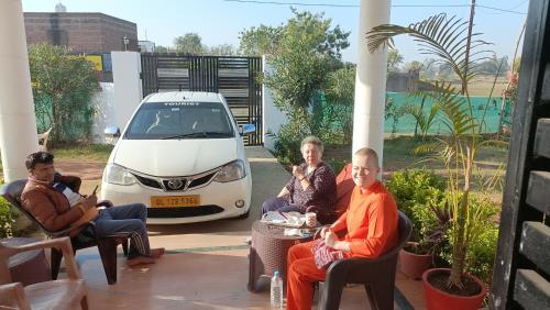 a group of people sitting in chairs in front of a car at The Mountain View Home Stay in Khajurāho