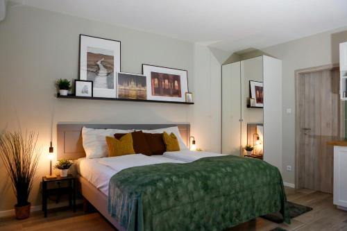 ein Schlafzimmer mit einem großen Bett und einer grünen Decke in der Unterkunft Akacfa Holiday Apartments in Budapest