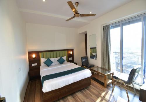 a hotel room with a bed and a large window at Hotel Candor Amigo Airoli Mind Space in Navi Mumbai