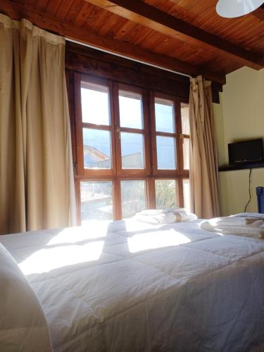 een slaapkamer met een groot wit bed en een raam bij EL COLLAU in Llanes