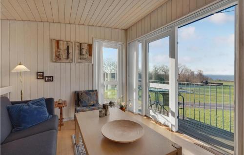a living room with a table and a large window at Amazing Home In Faaborg With Sauna in Fåborg