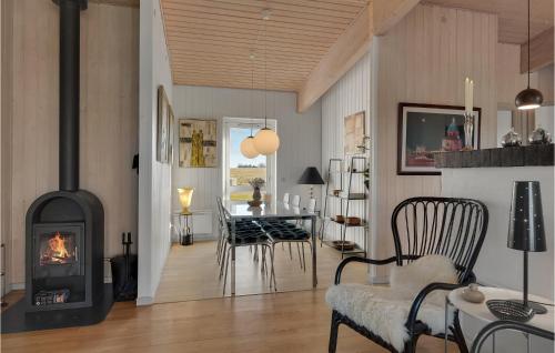 a living room with a fireplace and a dining room at Amazing Home In Faaborg With Sauna in Fåborg