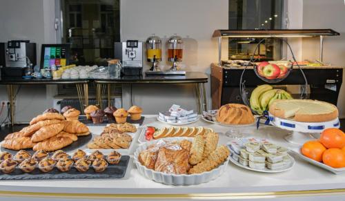 uma mesa cheia de diferentes tipos de pastelarias e tartes em Hotel George Vienna em Viena