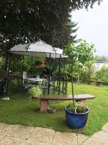 een tafel en bank met een paraplu in een tuin bij Ferienzimmer Rogi in Reinhardshausen