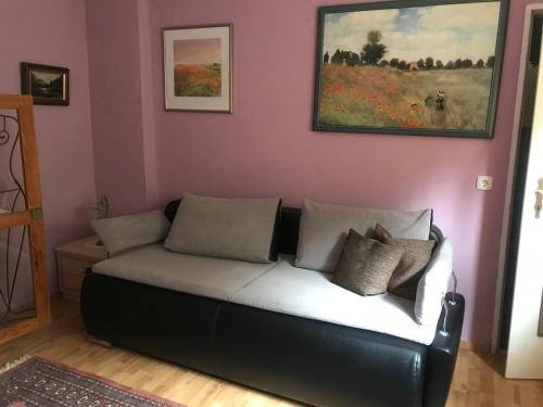 a couch in a living room with a painting on the wall at Ferienzimmer Rogi in Reinhardshausen