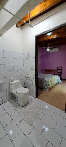 a bathroom with a toilet and a bed in a room at Ciudad Perdida EcoLodge in Cahuita