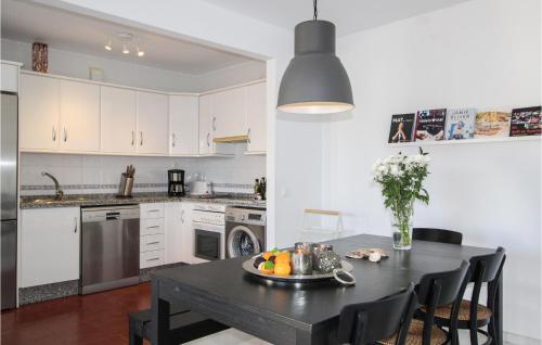 a kitchen with a black table and a kitchen with white cabinets at 3 Bedroom Stunning Apartment In Nerja in Nerja