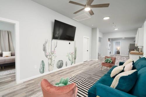 a living room with a blue couch and a flat screen tv at Cacti - Cactyou - Cactus in San Antonio