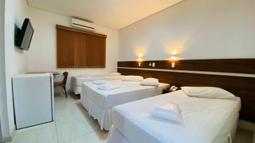 a room with a bunch of beds in it at Hotel Garrafão - Rua Principal de Boituva in Boituva