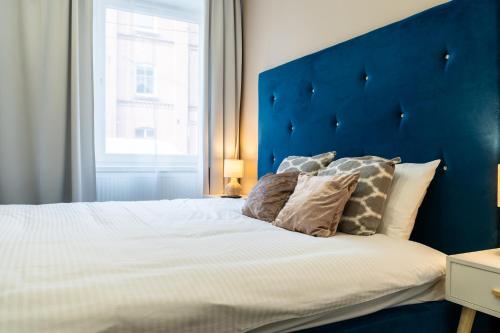 1 cama grande con cabecero azul y almohadas en Apartament Arena Gliwice Budget, en Gliwice