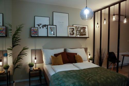 ein Schlafzimmer mit einem weißen Bett mit Bildern an der Wand in der Unterkunft Akacfa Holiday Apartments in Budapest