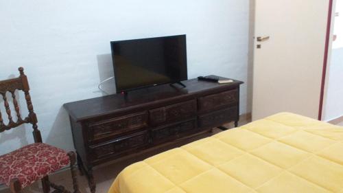 Habitación con TV en un tocador con silla en A 4 cuadras del ORFEO Alto verde 2 dormitorios en Córdoba