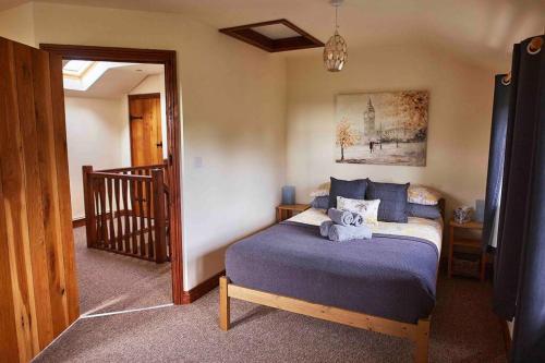 - une chambre avec un lit doté d'un ours en peluche dans l'établissement Bentra - Boutique Cottage at Harrys Cottages, à Pen y Clawdd