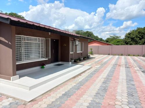 a house with a brick driveway in front of it at Kasuda Rooms - Cosy self contained rooms in Livingstone