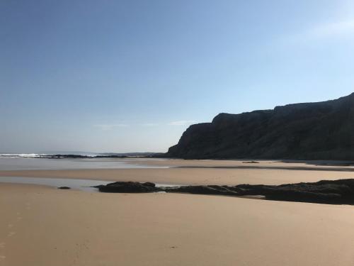 a sandy beach with a mountain in the background at Baleal, by the sea with swimming pool in Baleal