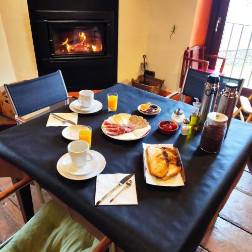 un tavolo con prodotti per la colazione e un camino di La Costa de Molló a Molló