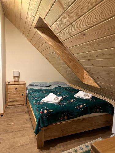 1 dormitorio con cama y techo de madera en Apartament Franio, en Jaworki