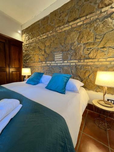 a bedroom with two beds and a stone wall at Agriturismo Tenuta de Castro in Aprilia