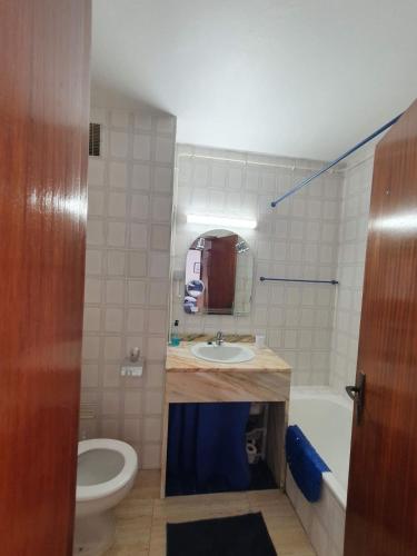 a bathroom with a sink and a toilet and a tub at T1- Praia da Rocha com piscina -segunda linha in Portimão