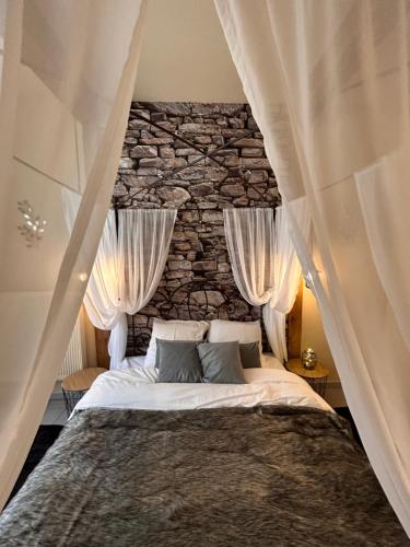 une chambre avec un lit avec un mur en pierre dans l'établissement Esprit ALSACE: 70m2 de charme, à Mulhouse