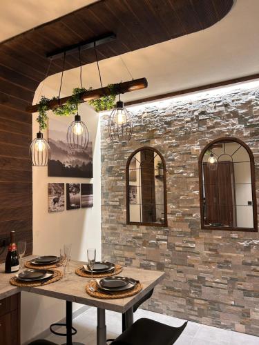 une salle à manger avec une table et un mur de briques dans l'établissement Esprit ALSACE: 70m2 de charme, à Mulhouse
